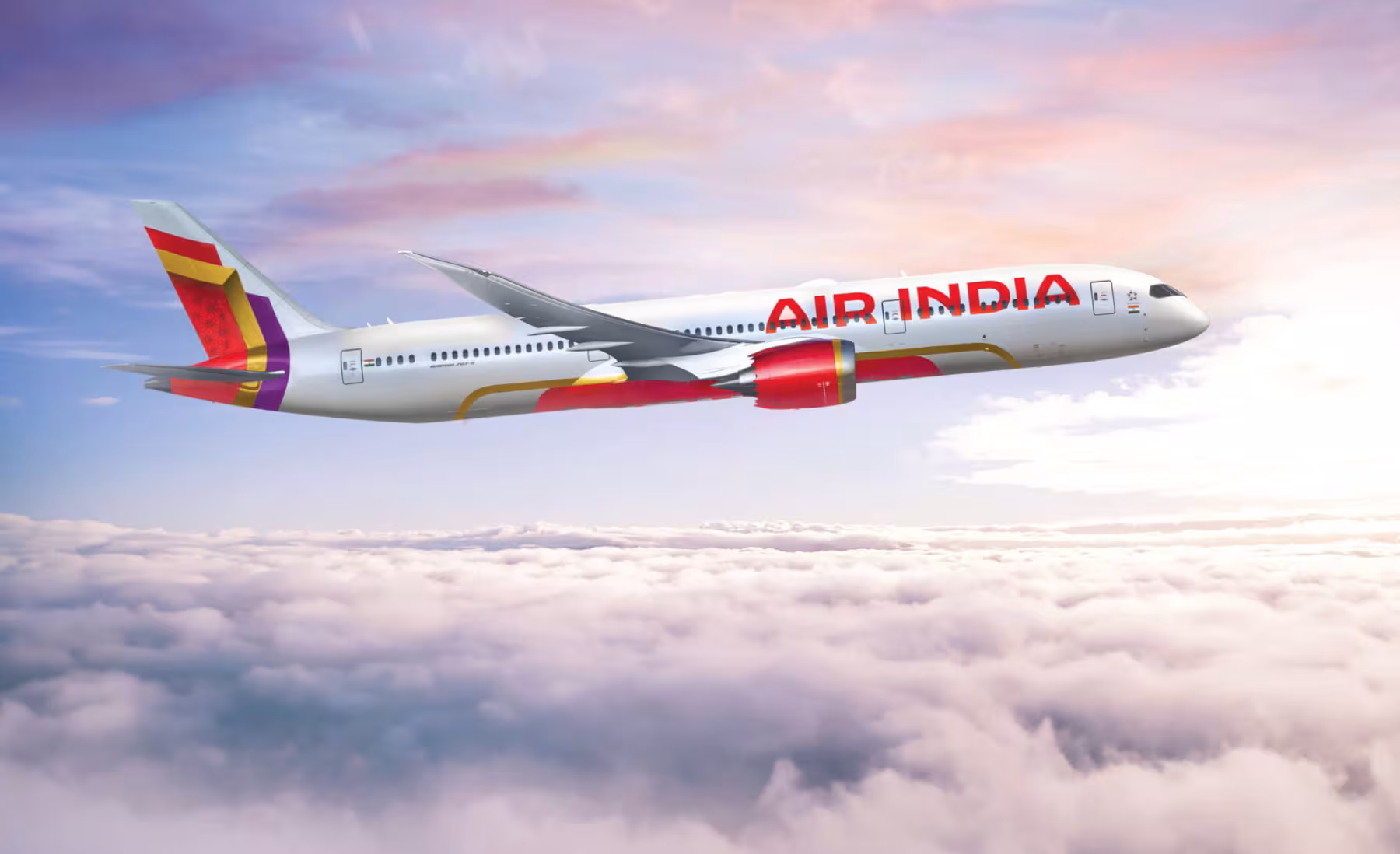 Air India airplane in flight, cruising over a sea of white clouds with a serene sky tinged in pink and blue hues. The aircraft&rsquo;s red-and-orange tail and engine accents stand out against the pale sky.