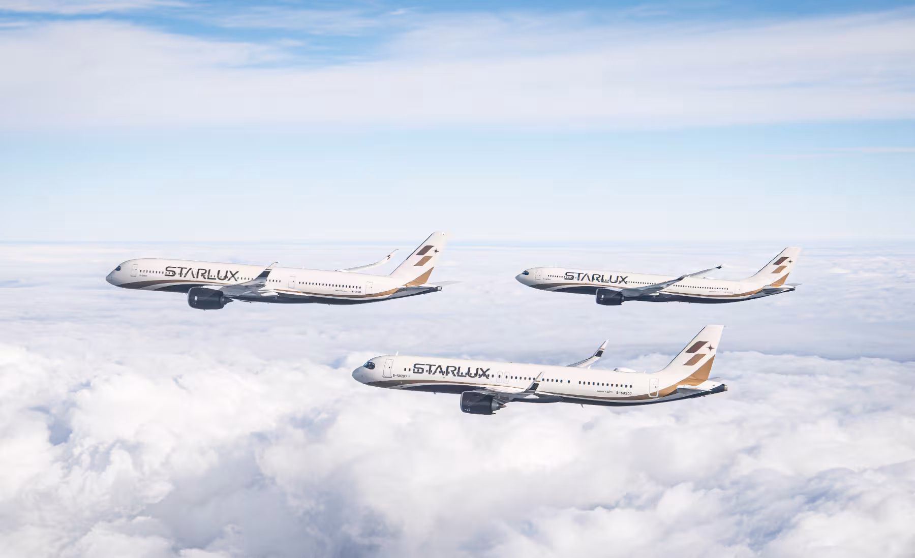 Three STARLUX Airlines aircraft flying in formation above the clouds under a blue sky.
